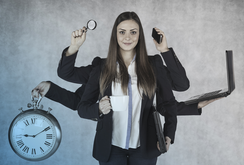 A woman with multiple arms holds a magnifying glass, a phone, a laptop, a clock, and a cup, symbol